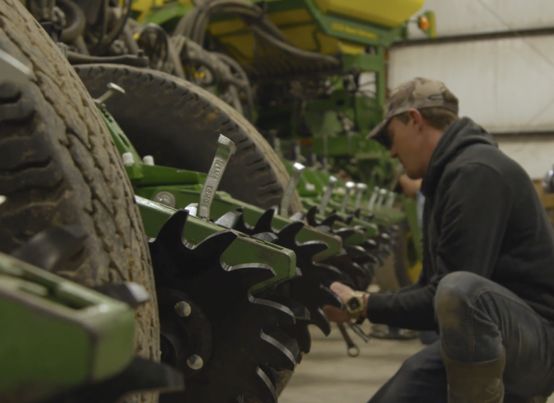 Kelly-Garrett-planter-spring2021 A farmer works on Kelly Garrett's John Deere planter in the shop