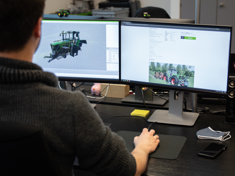 farming-simulator-giants-software A designer at GIANTS Software working on a 3D model of a tractor for use in the game Farming Simulator.